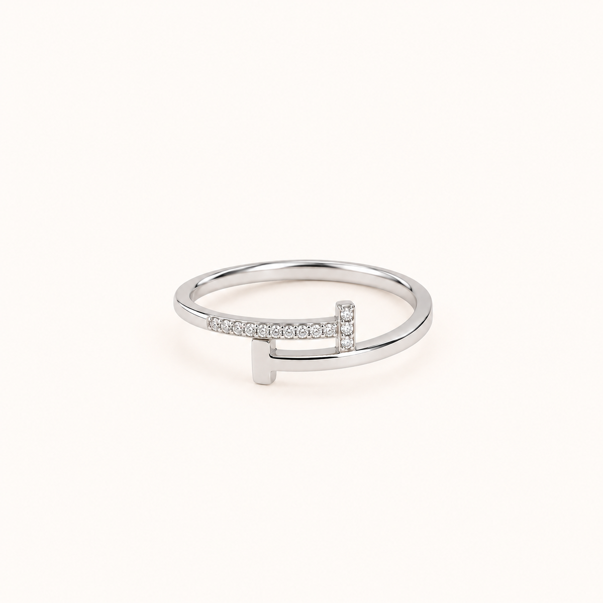 Silver waterproof ring with clear pavé stones and a polished silver finish, photographed on a soft ivory background.