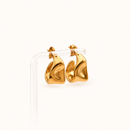 Gold waterproof sculptural chunky hoop earrings on a neutral background