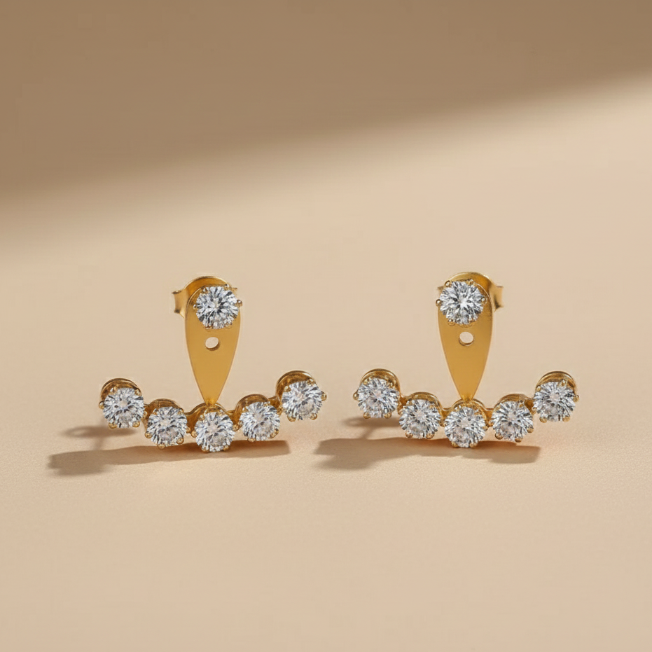 Gold earrings with diamond stones on a beige background