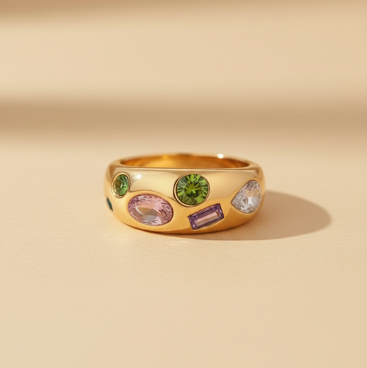 Gold ring with colorful gemstones on a beige background